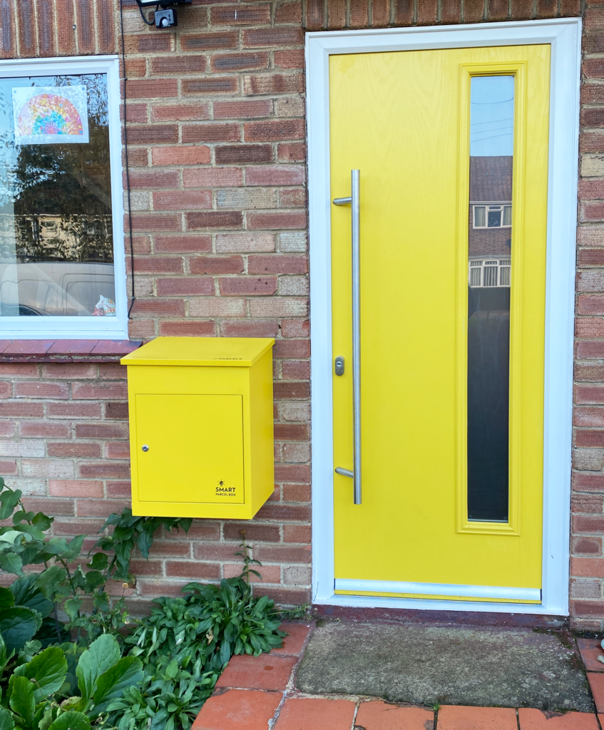 Kundenfoto: Gelber Smart Parcel Box Paketkasten an der Wand montiert. Erhältlich in unserem Online-Shop für 159,99 €