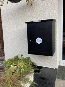 Kundenfoto: Mittelgroße schwarze Smart Parcel Box Paketbox an der Wand montiert. Erhältlich in unserem Online-Shop für 159,99 €.